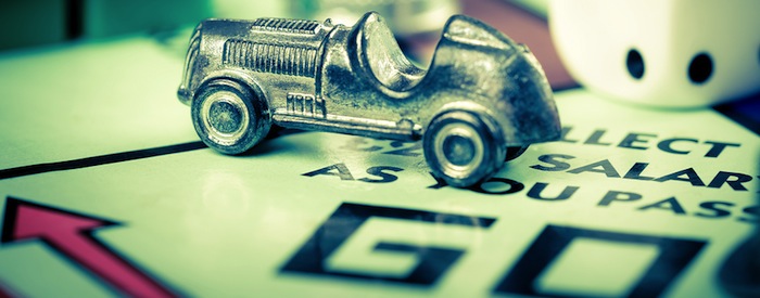 LONDON,UK - FEBRUARY 11, 2015 : Tokens and dice next to the GO space in a Monopoly game board